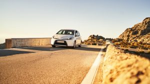Modern vehicle driving on road in highlands