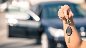 Man's hand holding modern car keys ready for rental