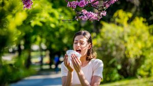 Una chica estornuda debido a su alergia.