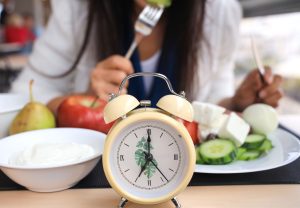 Una mujer disfrutando de una dieta sana y equilibrada con un contador de tiempo.