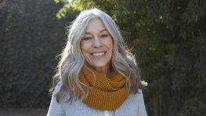 Portrait of woman with long gray hair looking at camera smiling
