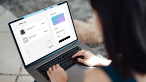 Woman shopping clothes online on laptop and making payment with credit card