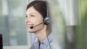 Receptionist wearing headset, smiling cheerfully