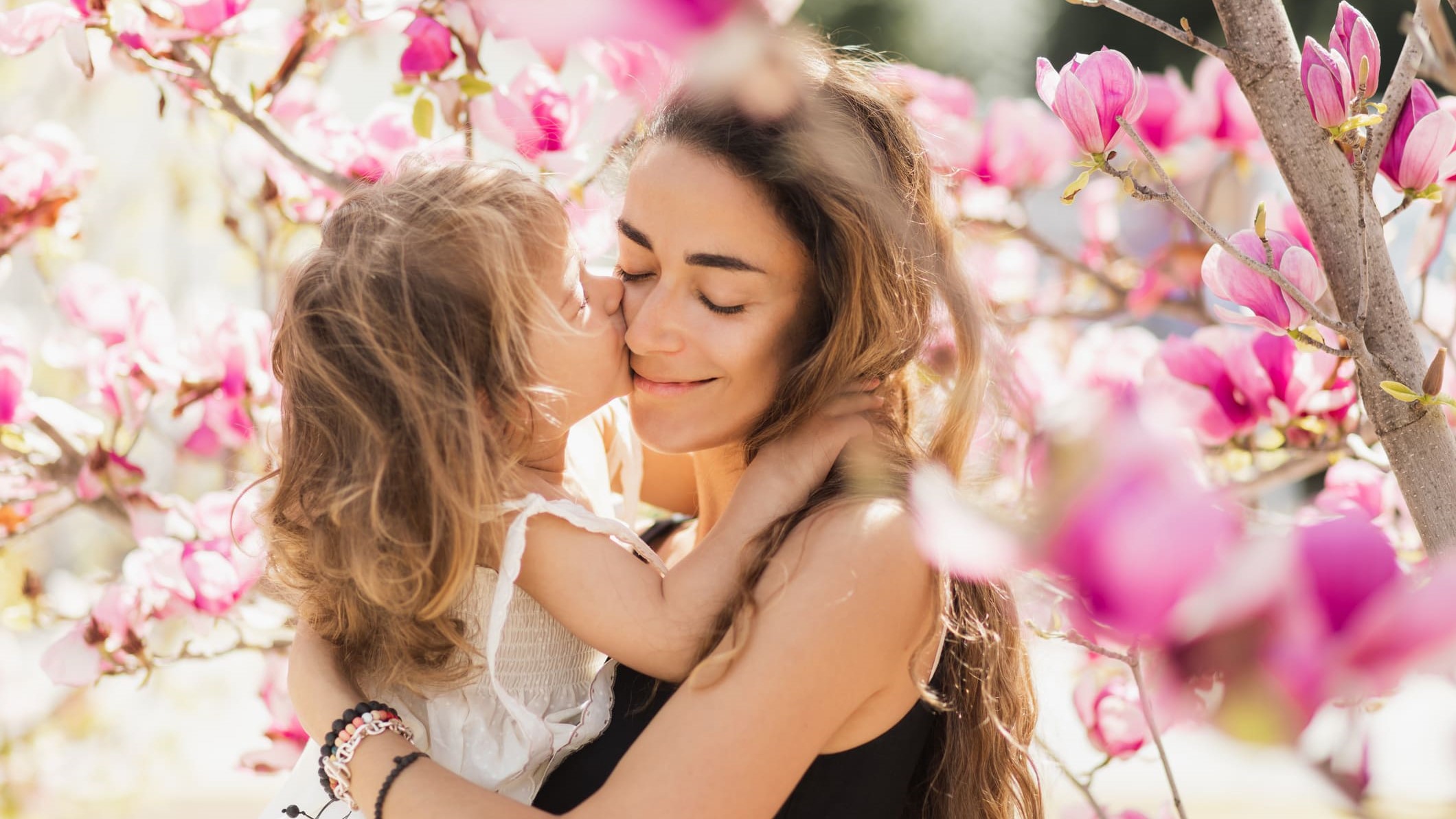 Una hija besa y abraza a su madre.