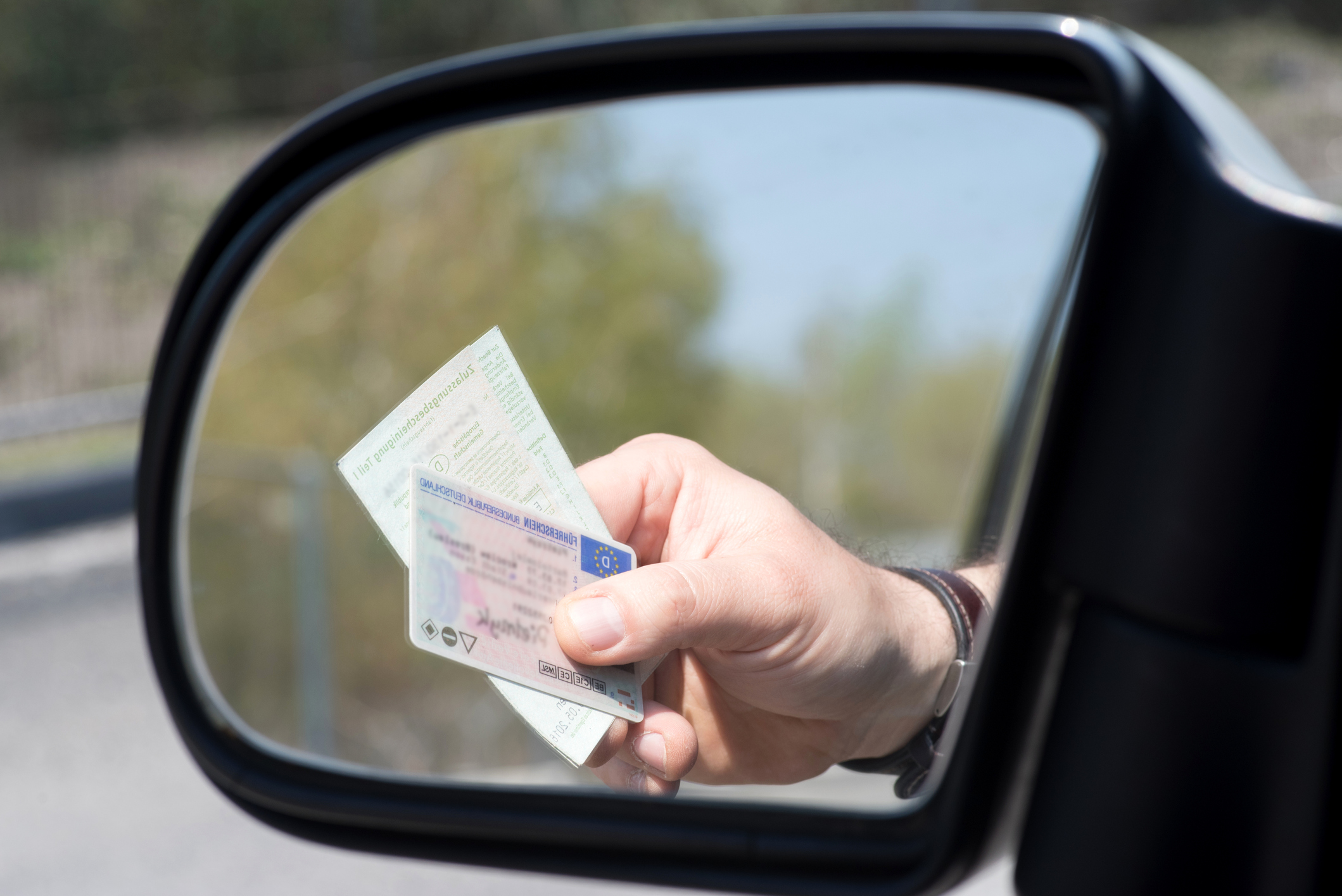 Una persona muestra el carnet de conducir y el permiso de su circulación de su vehículo.