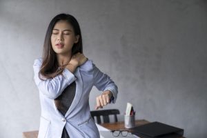 Una chica siente muchos dolores musculares a causa de la fibromialgia.