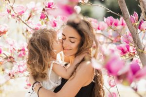 Una hija besa y abraza a su madre.