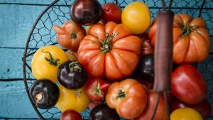 Different heirloom tomatoes in a wire basket