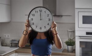 Una chica cogiendo el reloj a las 00:00 horas.