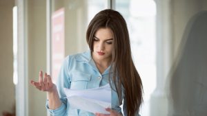 Portrait of a young woman reading bad letter