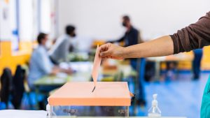 Autonomous community of Madrid elections. Democraty referendum for government vote. Hand posing an envelop in a ballot box for community elections