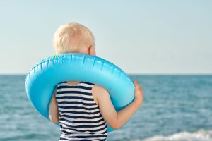 Un niño usando un flotador antes de meterse en el agua
