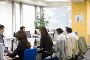 Varios empleados de un call center atendiendo llamadas comerciales.