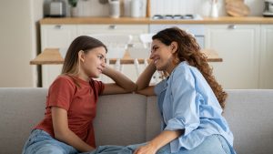 Loving mother listening to daughter with empathy and understanding, child sharing secrets with mom