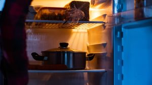 young woman opening the fridge.