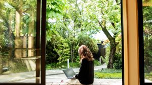 A female guest working on the porch of the guesthouse where she stayed during her trip to Japan.