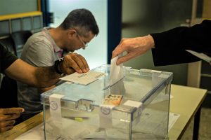 Un ciudadano depositando su voto en la urna electoral.