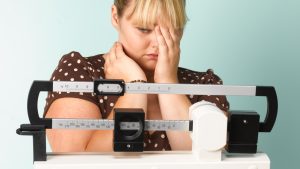 Obese teenager on scales