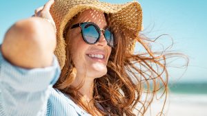 Una chica luciendo un pelo brillante y sano en la playa.