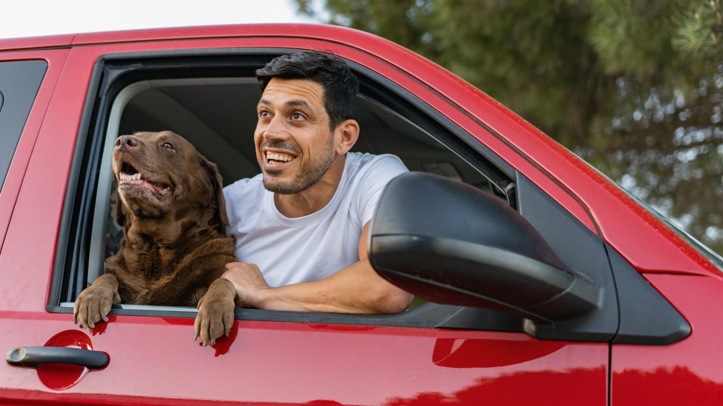Un dueño junto a su perro disfrutando de su viaje en coche.