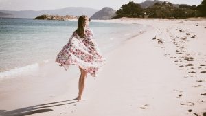 Woman walking along the beach in the Cies islands