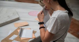 Una chica depositando su voto por correo en las oficinas de Correos.
