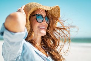 Una chica luciendo un pelo brillante y sano en la playa.