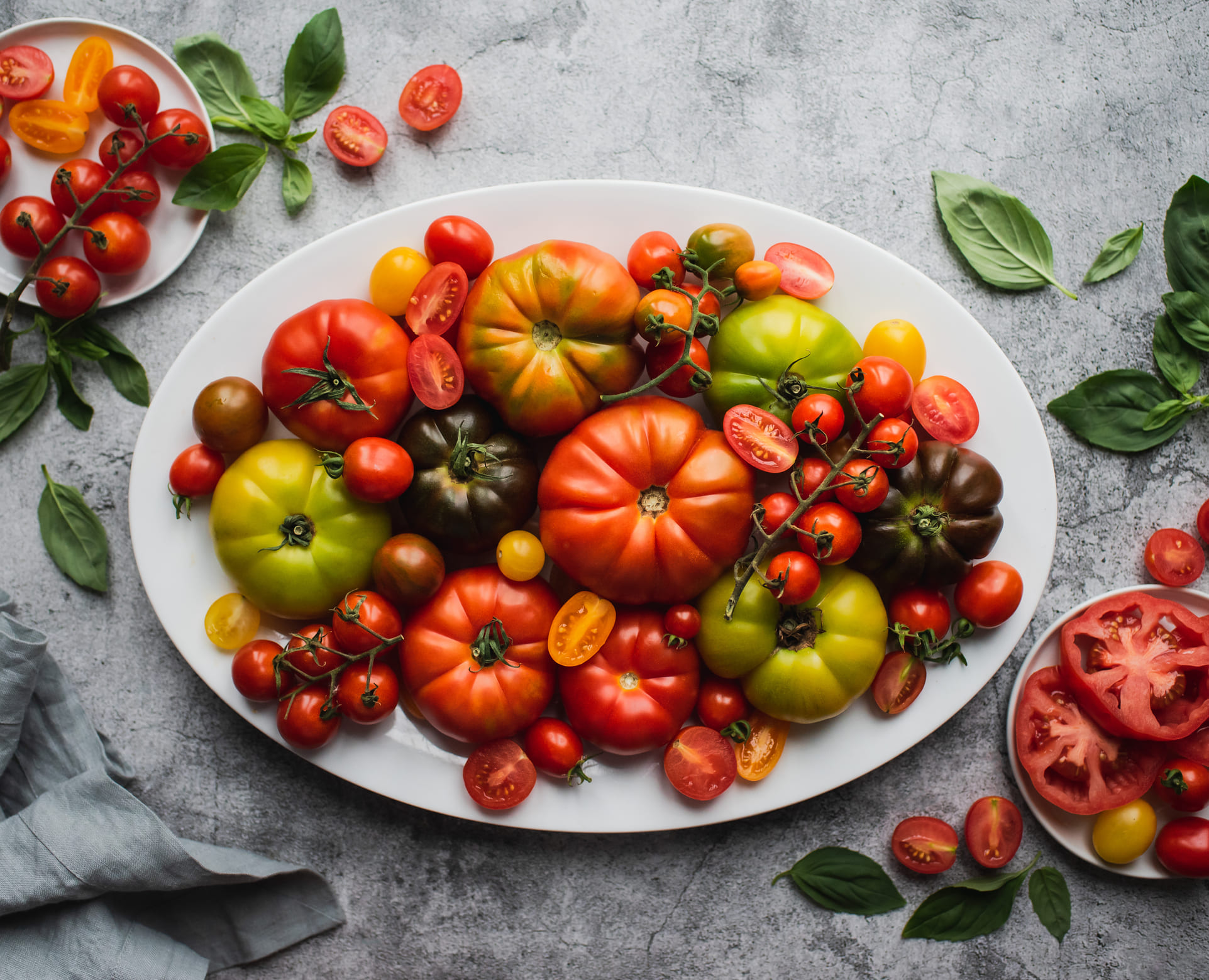 Diferentes tipos de tomate servidos en una plato.