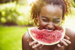 Una chica mordiendo Alimentos refrescantes como la sandía o el melón.