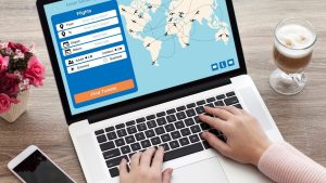 female hands on laptop keyboard with application search air ticket