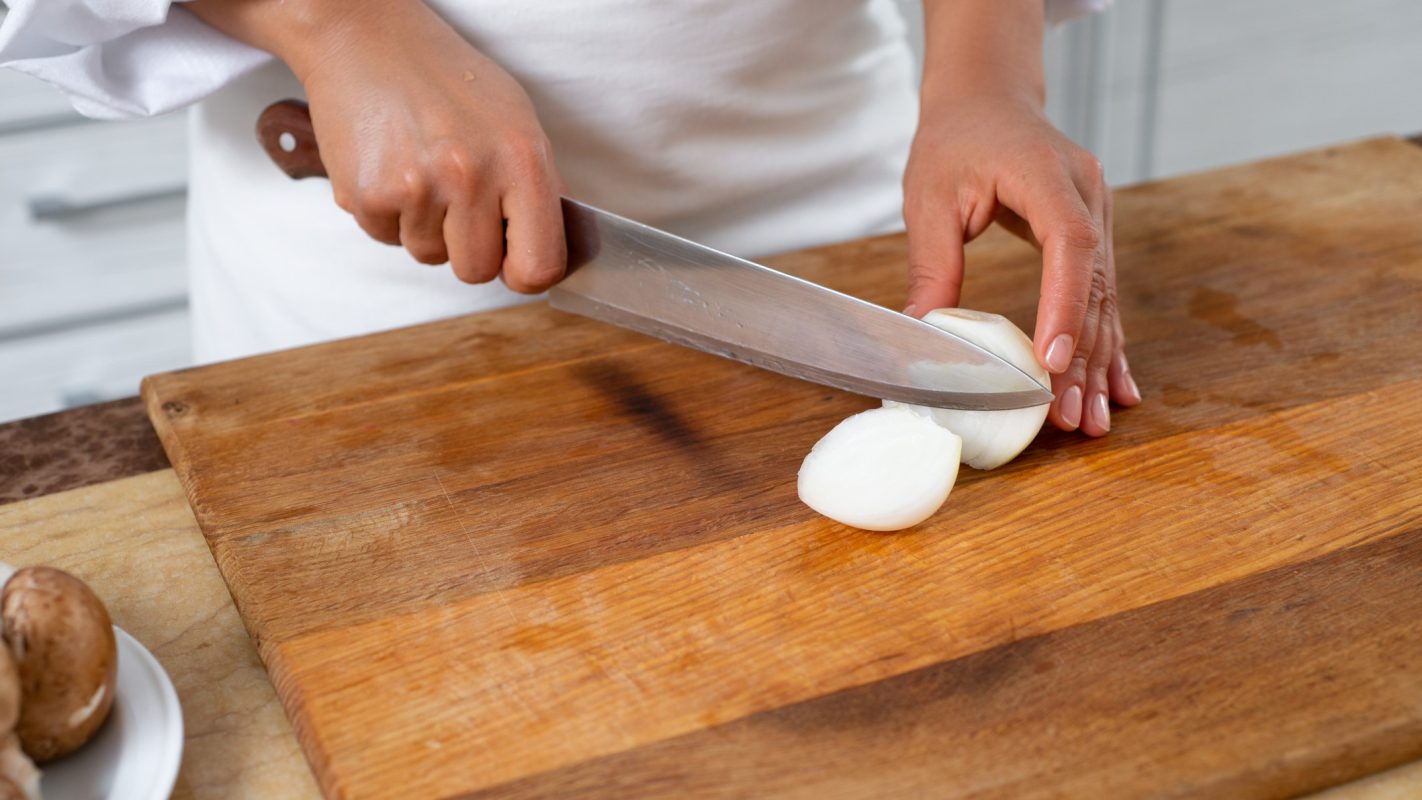 Una persona cortando cebolla.