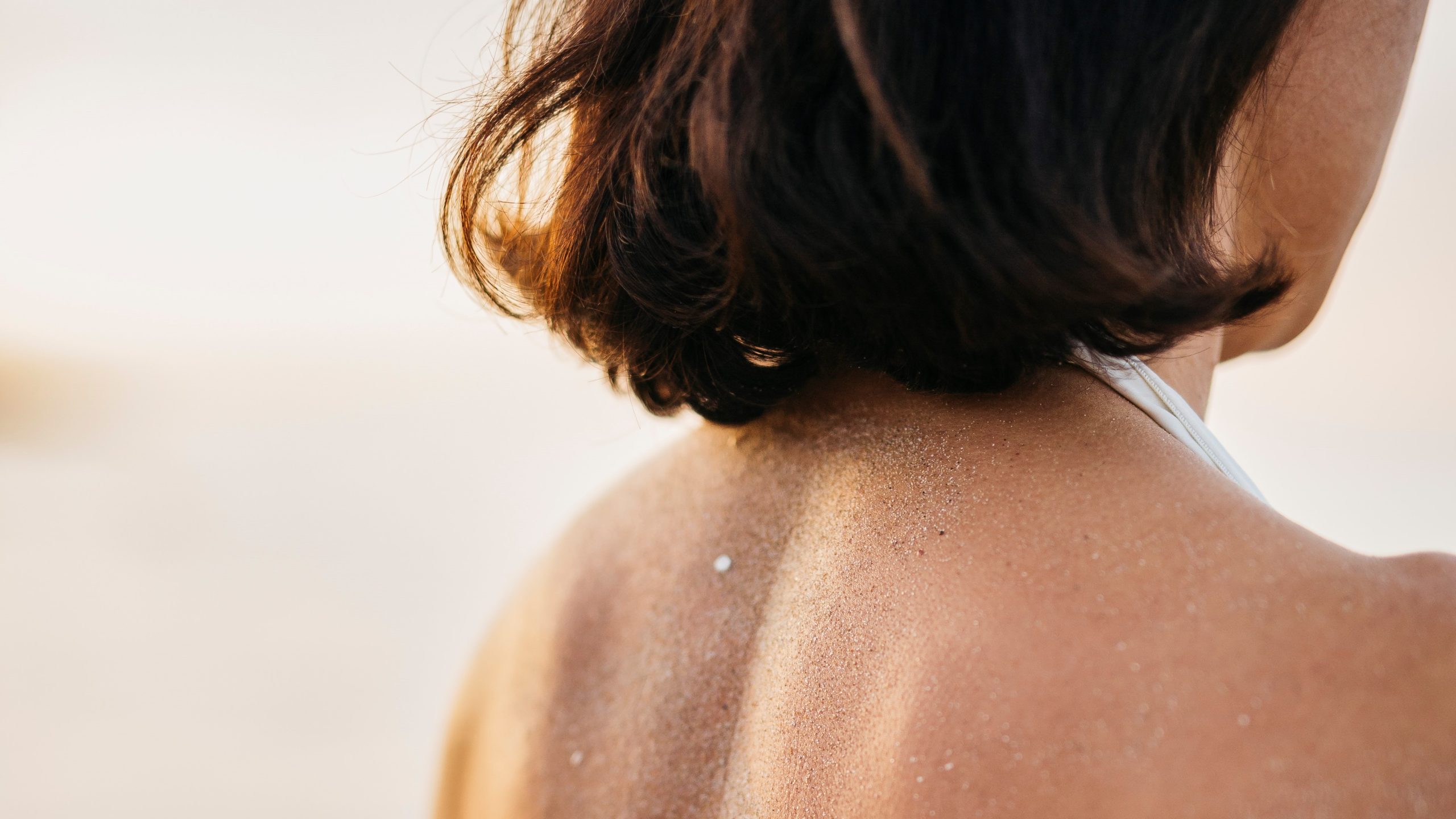 Espalda de una chica llena de arena.