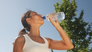 Woman drinking water outdoors