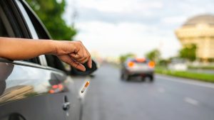 Young man smoking a cigarette in car.cigarette butt / casualness that often happens with a lot of people make a derty house