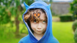 Un niño pone una mueca cuando se le posa una mariposa (Getty)