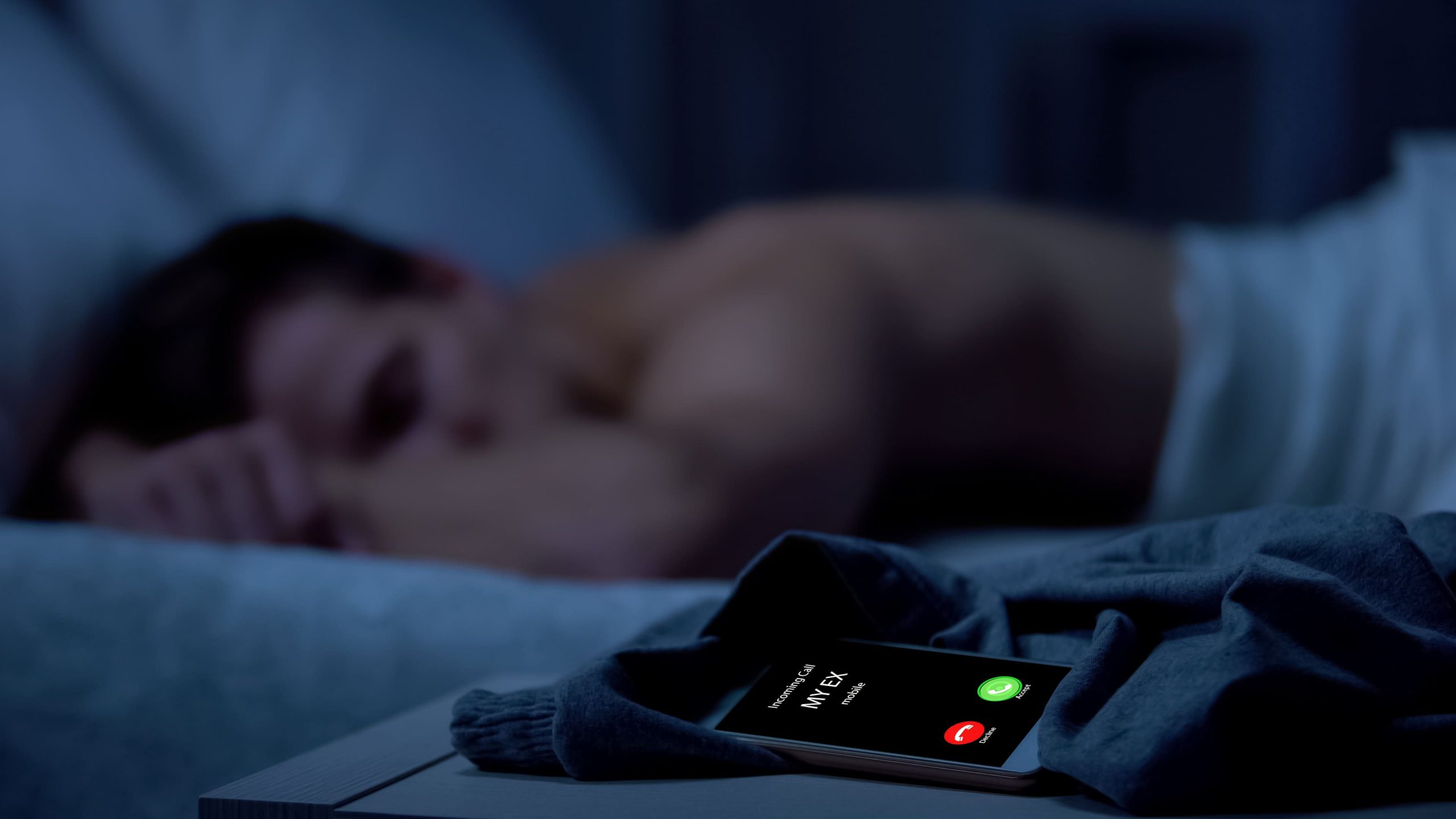 Un chico intentando dormir, mientras la expareja le llama por teléfono.