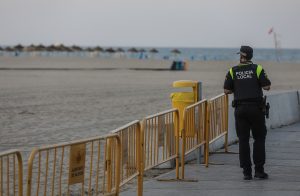 Un policía local observando que la bolsa y las pertenencias de los bañistas no sean robados.