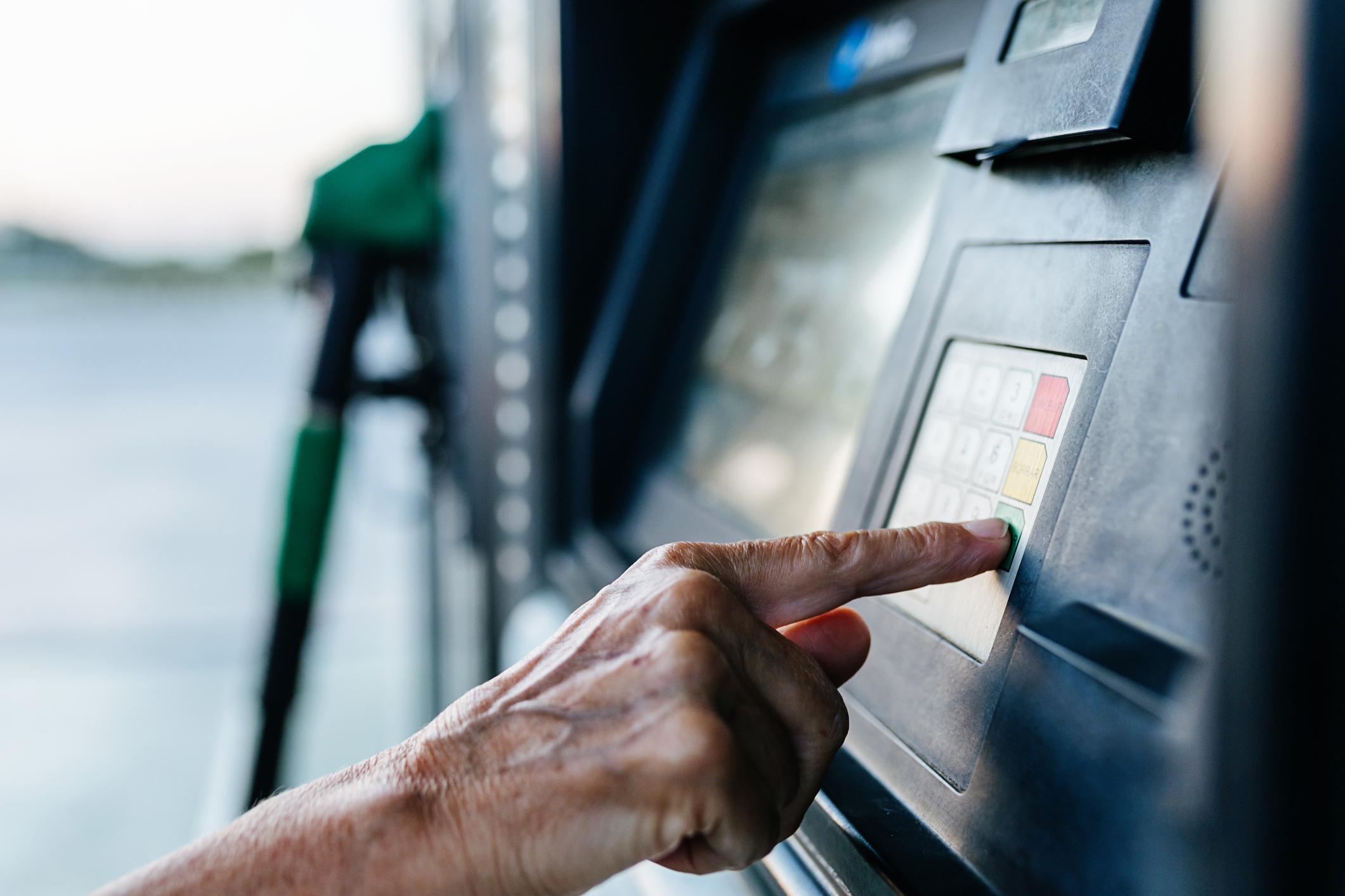 Una mujer pagando en una gasolinera después de repostar.