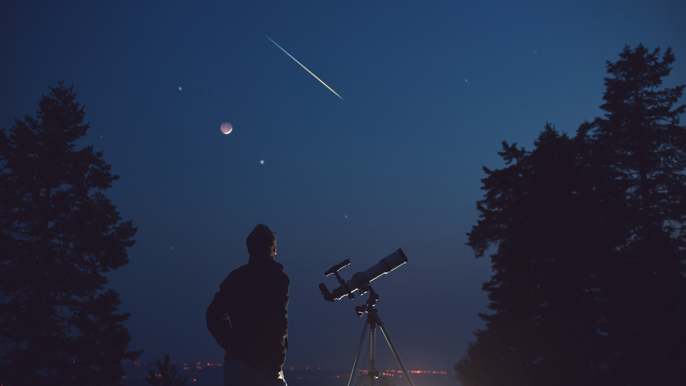 Un chico observando a través de un telescopio las estrellas fugaces en el cielo.