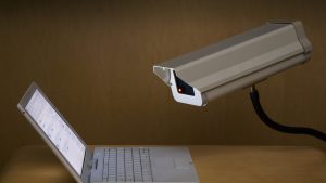 Surveillance camera peering into laptop computer