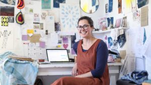 Casa, hogar, bienestar a Woman working on her laptop in her home studio.