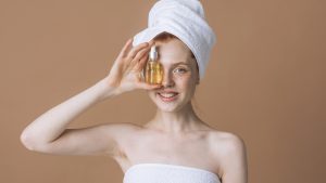 happy woman holding face oil bottle in her hands.cosmetics and body care concept