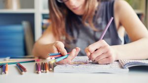 Young woman colouring in an adult colouring book