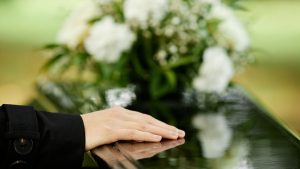 Close up of female hand on coffin
