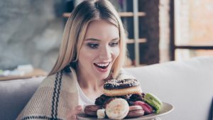 Diet is finished! Wow! Yum-yum! beautiful excited happy glad joyful woman is going to eat sweets, donuts and macaroons at the weekend, she is alone and nobody sees her!