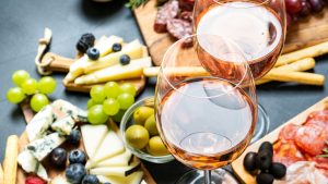 Two glasses of rose wine with cheese and salami, olives