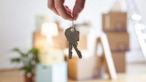 Close-up of woman holding house key in new home