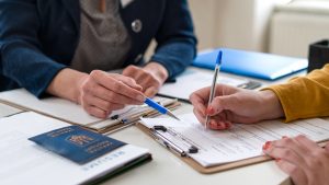 Close-up of filling in paper form and ukrainian passport.