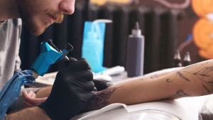 Tatuador trabajando. (Créditos: Liudmila Chernetska)