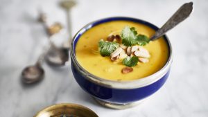 Bowl of butternut squash soup, garnished with toasted almonds and parsley